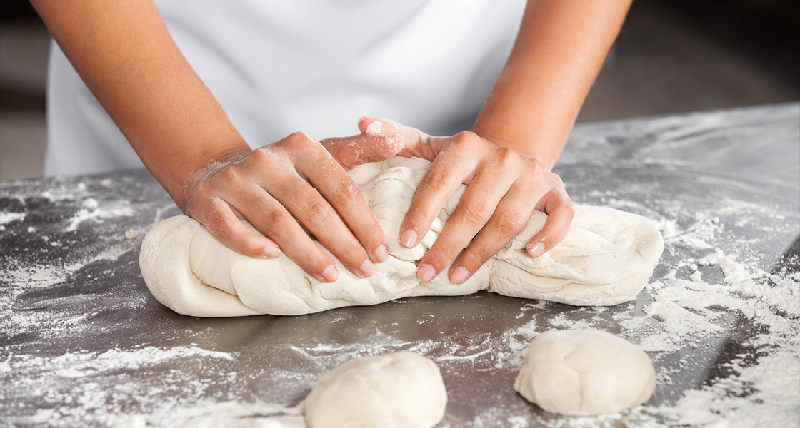 Chef hands and dough press for baking preparation