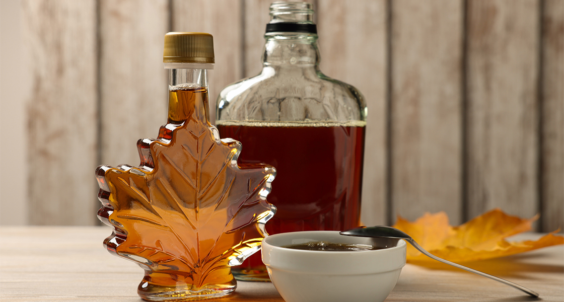 Maple syrup in bottles and in a bowl.