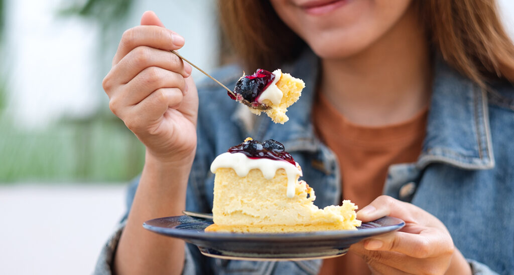 A woman eating a slice of cake