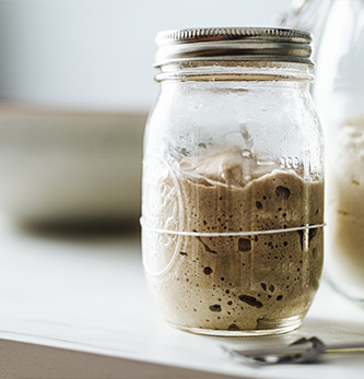 Image of 2 glass bottles with Sourdough fermenting